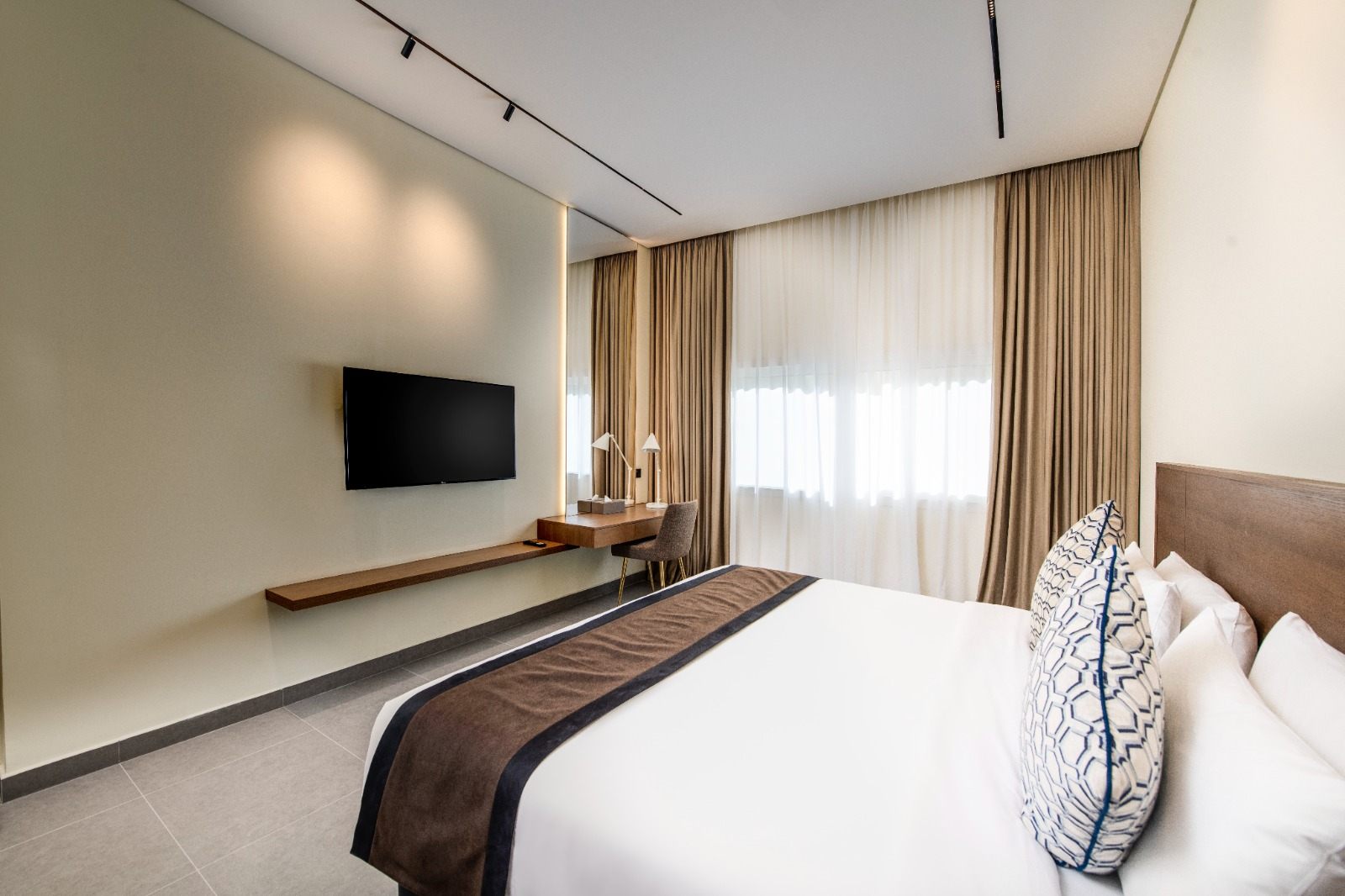 Bedroom with King bed, work desk and full-height curtains