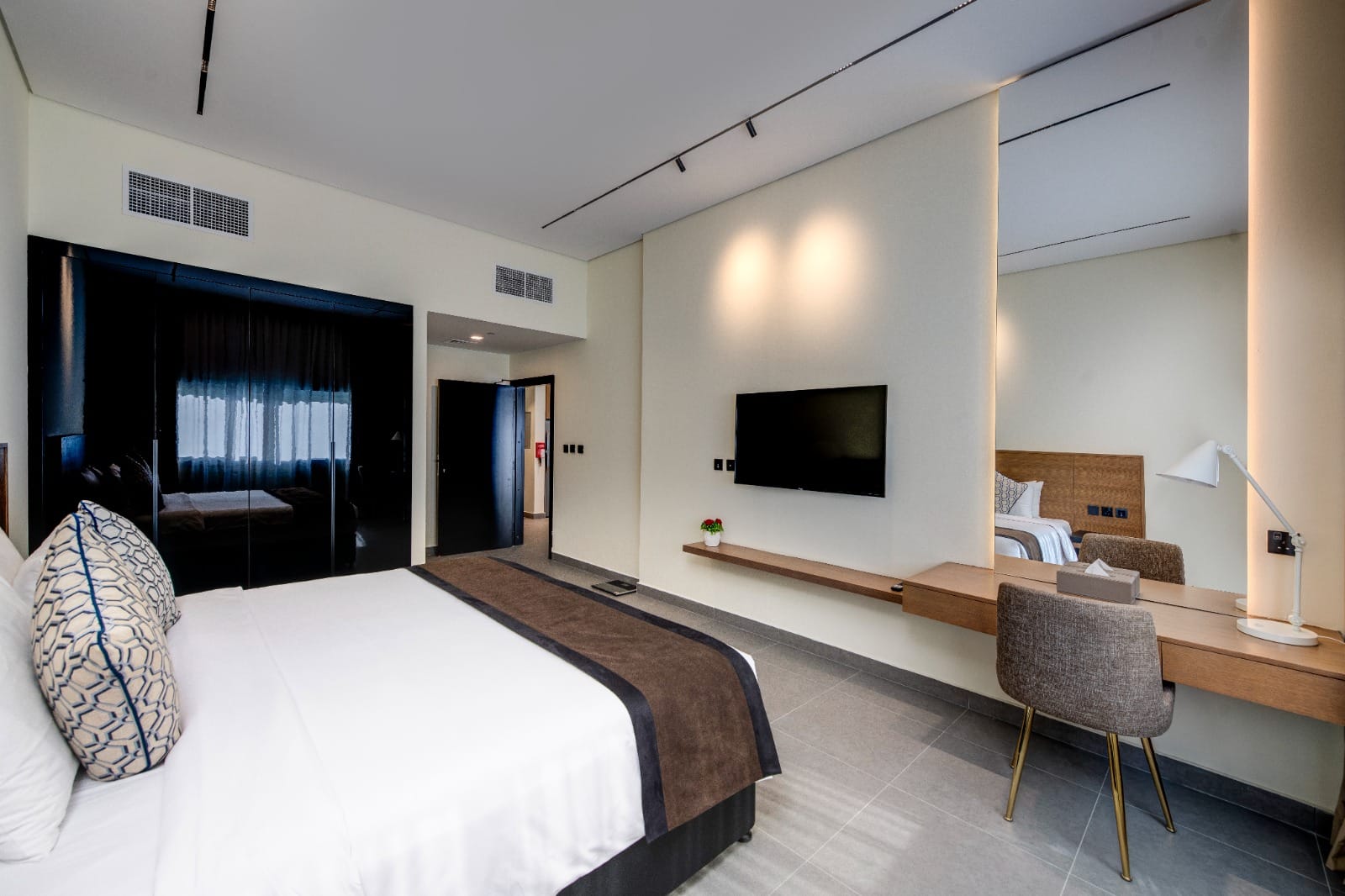 Spacious bedroom with mirrored wardrobe in a larger residence