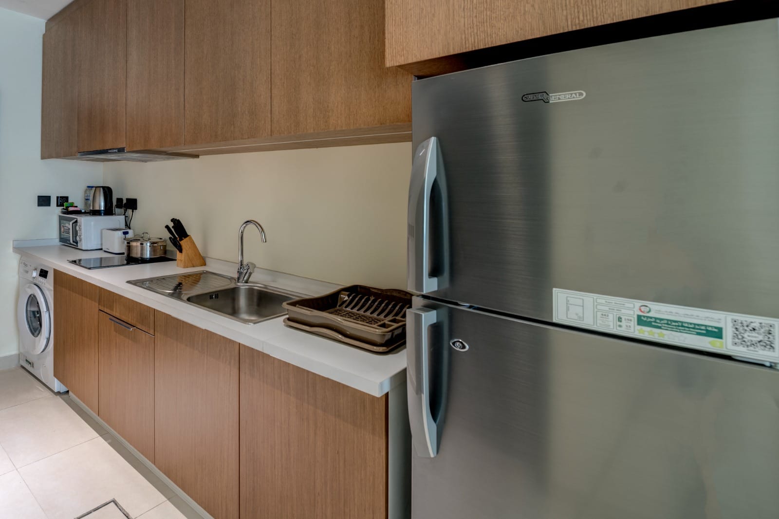 Studio apartment kitchenette with timber cabinetry and washer
